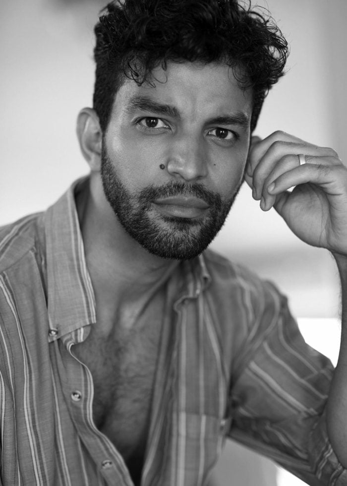 Close-up portrait of Carlos Gonzalez with curly hair and a beard