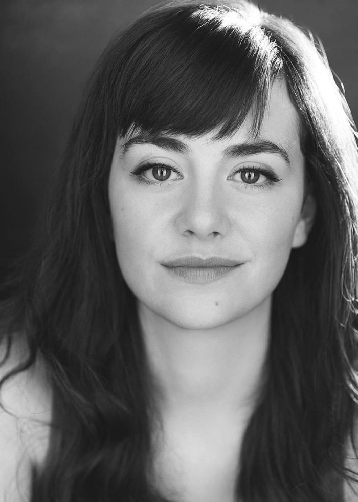 Black and white headshot of Celeste Arias with long hair and bangs.