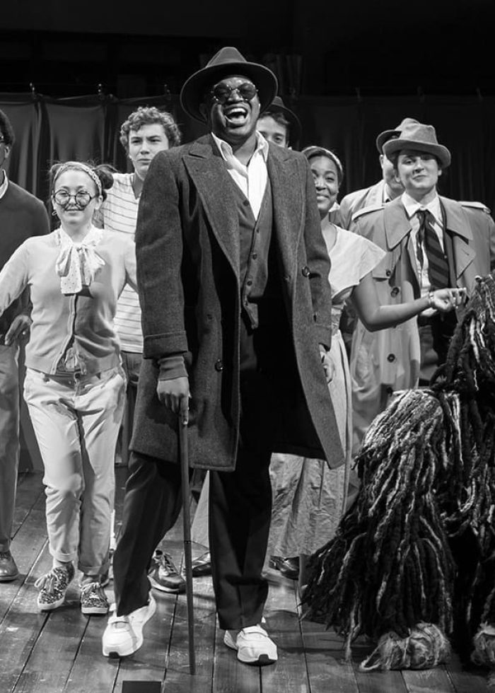 Cast of a children's theater show, possibly a Best NYC Kids’ Theater Show, on stage with a dog puppet.