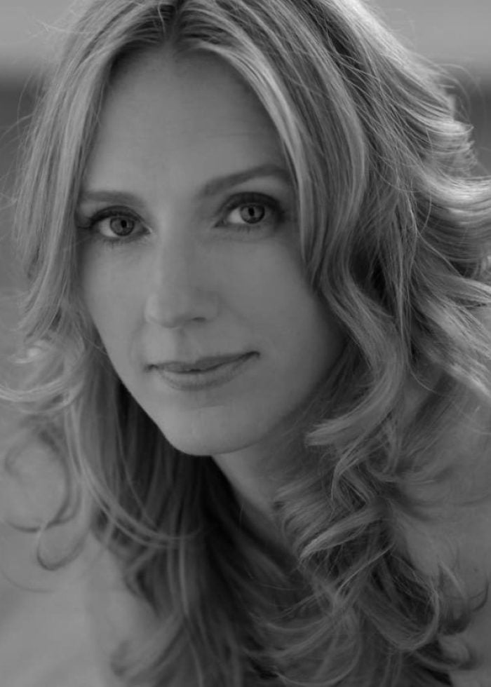 Black and white portrait of actress Christina Kirk with wavy blonde hair, looking at the camera.