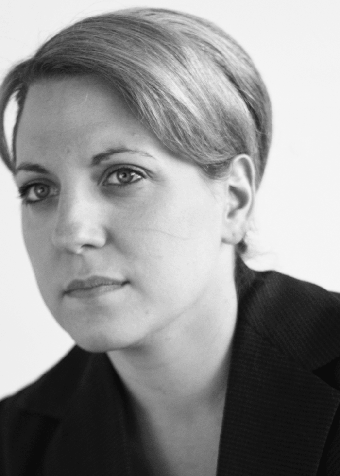 Woman with short hair in a dark blazer, looking at the camera.