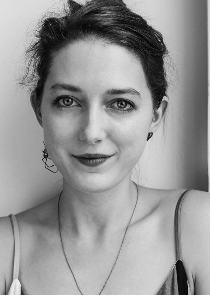 Black and white portrait of Clare Barron, looking directly at the camera.