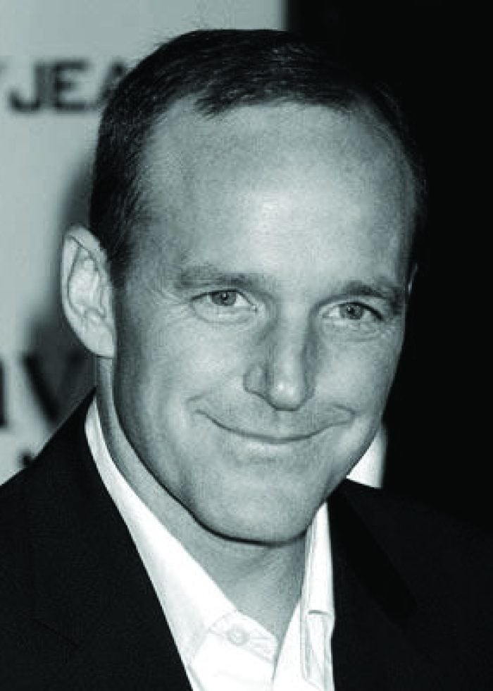 Clark Gregg smiling at an event, wearing a suit