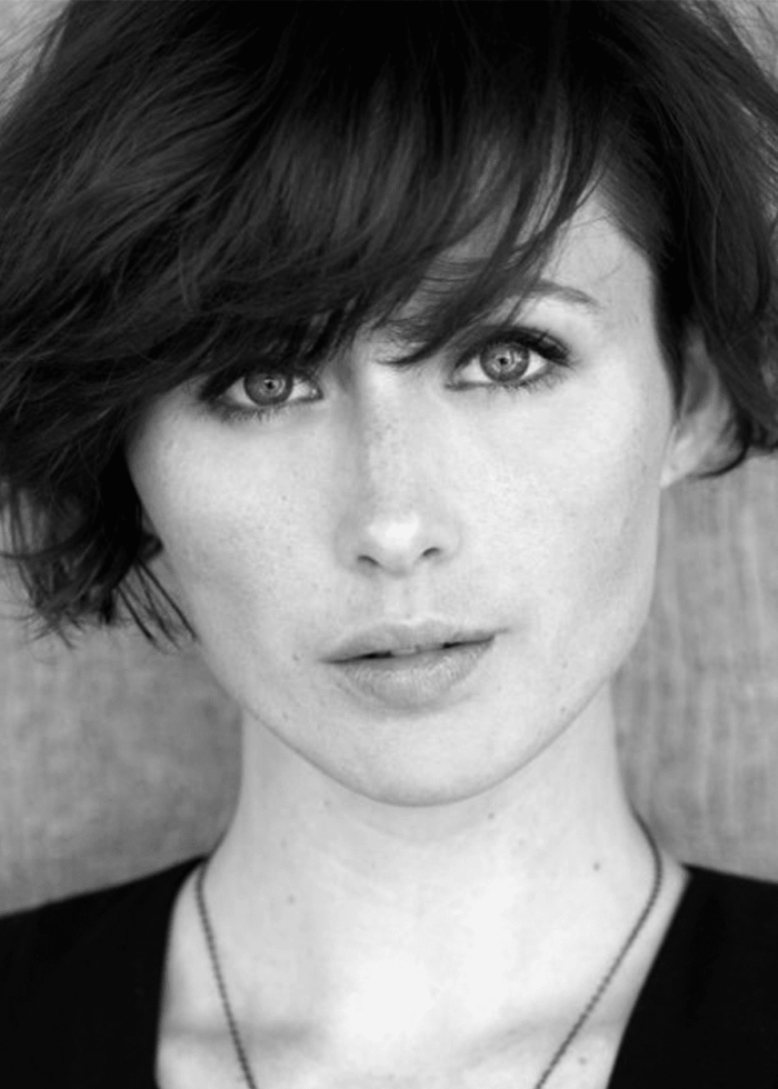 Portrait of a woman with short dark hair, looking directly at the camera.