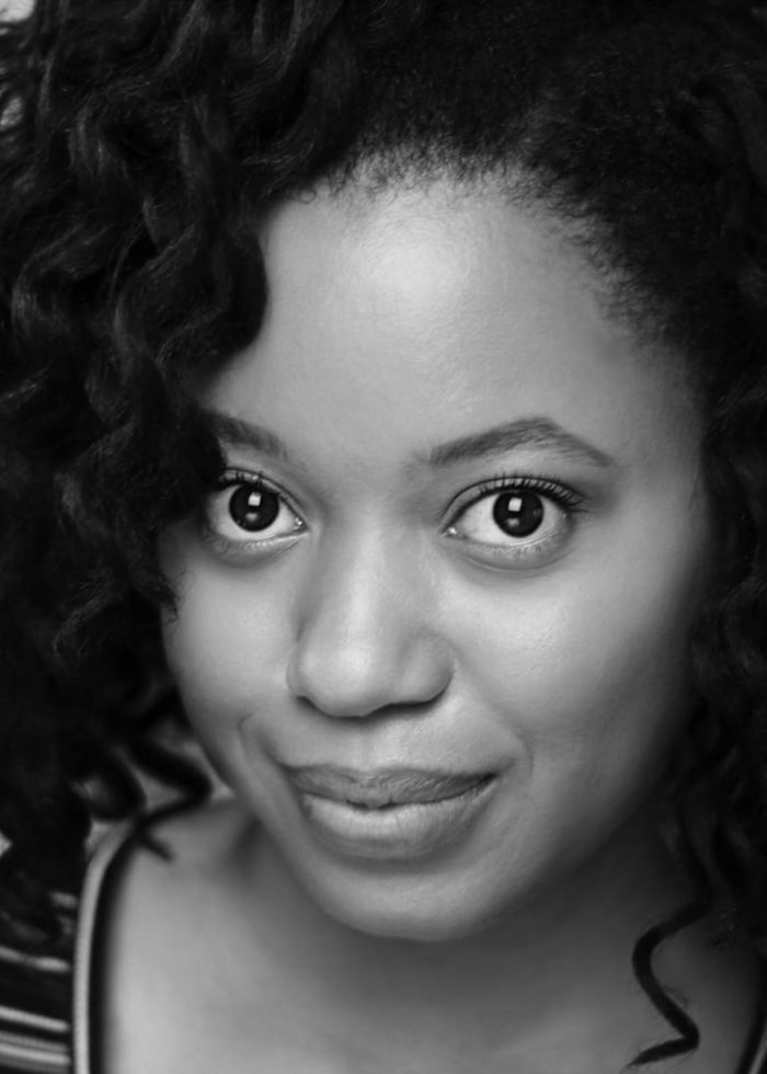 Headshot of Cynthia Nesbit with curly hair, looking directly at the camera.
