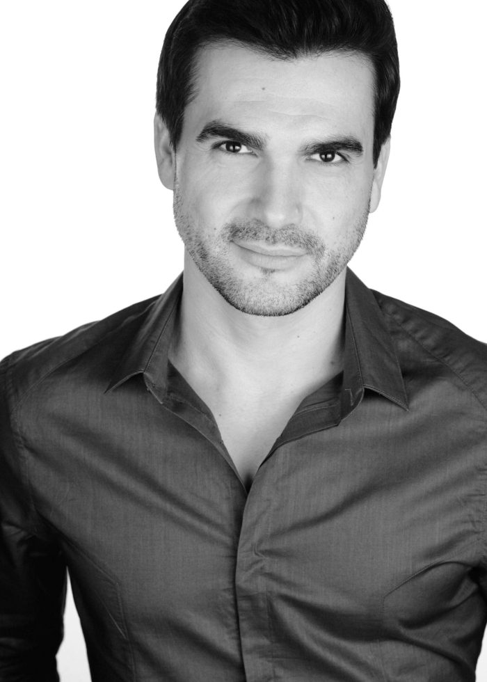 Dan Domingues, handsome man in a dark shirt, looking at the camera.