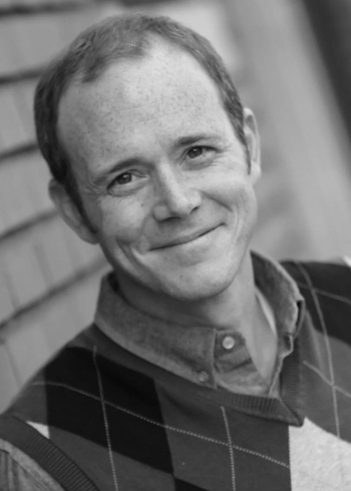 Smiling man with freckles wearing an argyle sweater vest