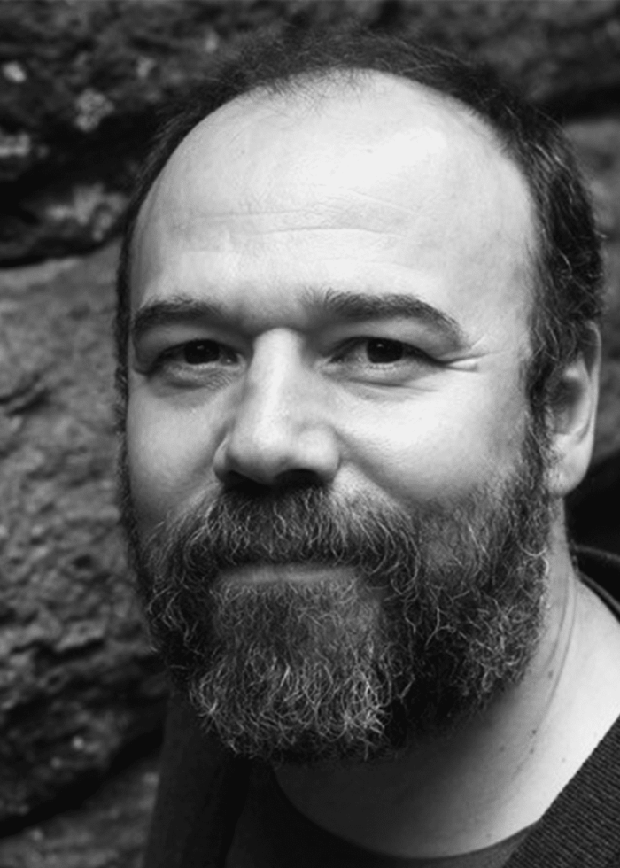 Danny Burstein, actor, with a beard, smiling at the camera.
