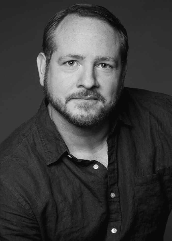 Darren Goldstein, headshot in a dark blue shirt, looking directly at the camera.