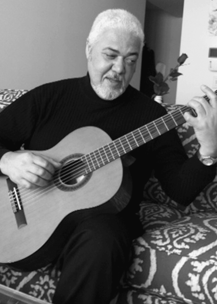 David Oquendo playing a classical guitar, a musician performing.