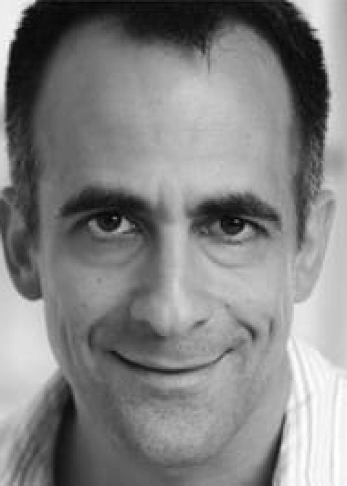 David Pittu, smiling in a black and white headshot.