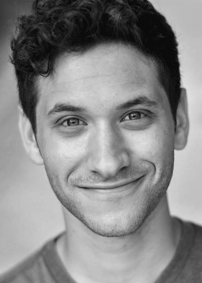 Headshot of Donovan Mendelovitz, smiling with curly hair.
