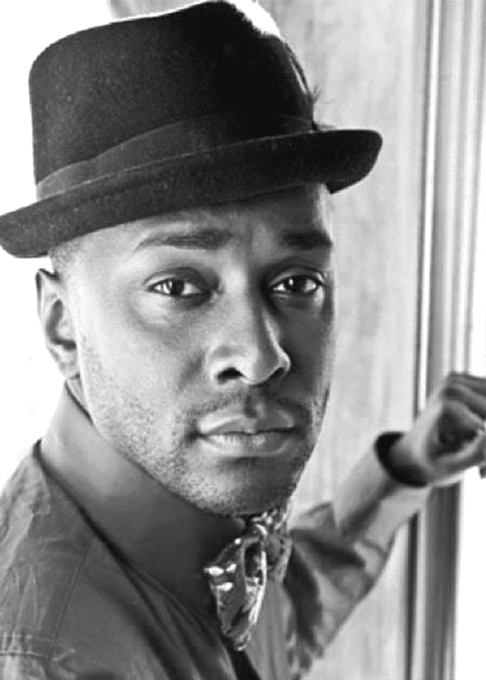 Black and white portrait of a man in a fedora.