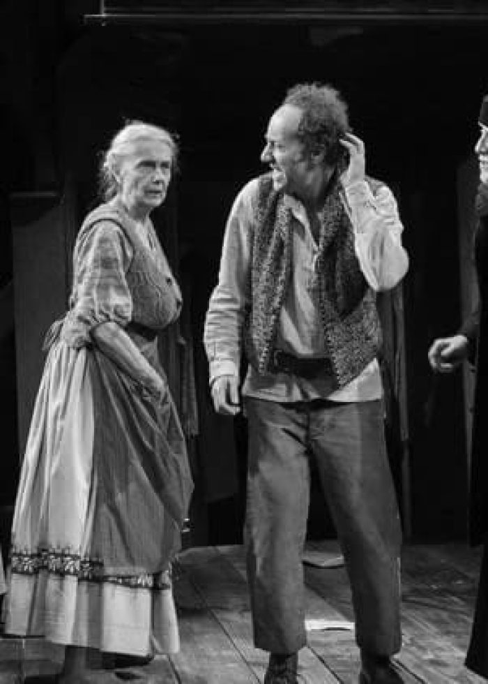 Actors in a scene from the play "Dying for It." Period costumes, stage performance.