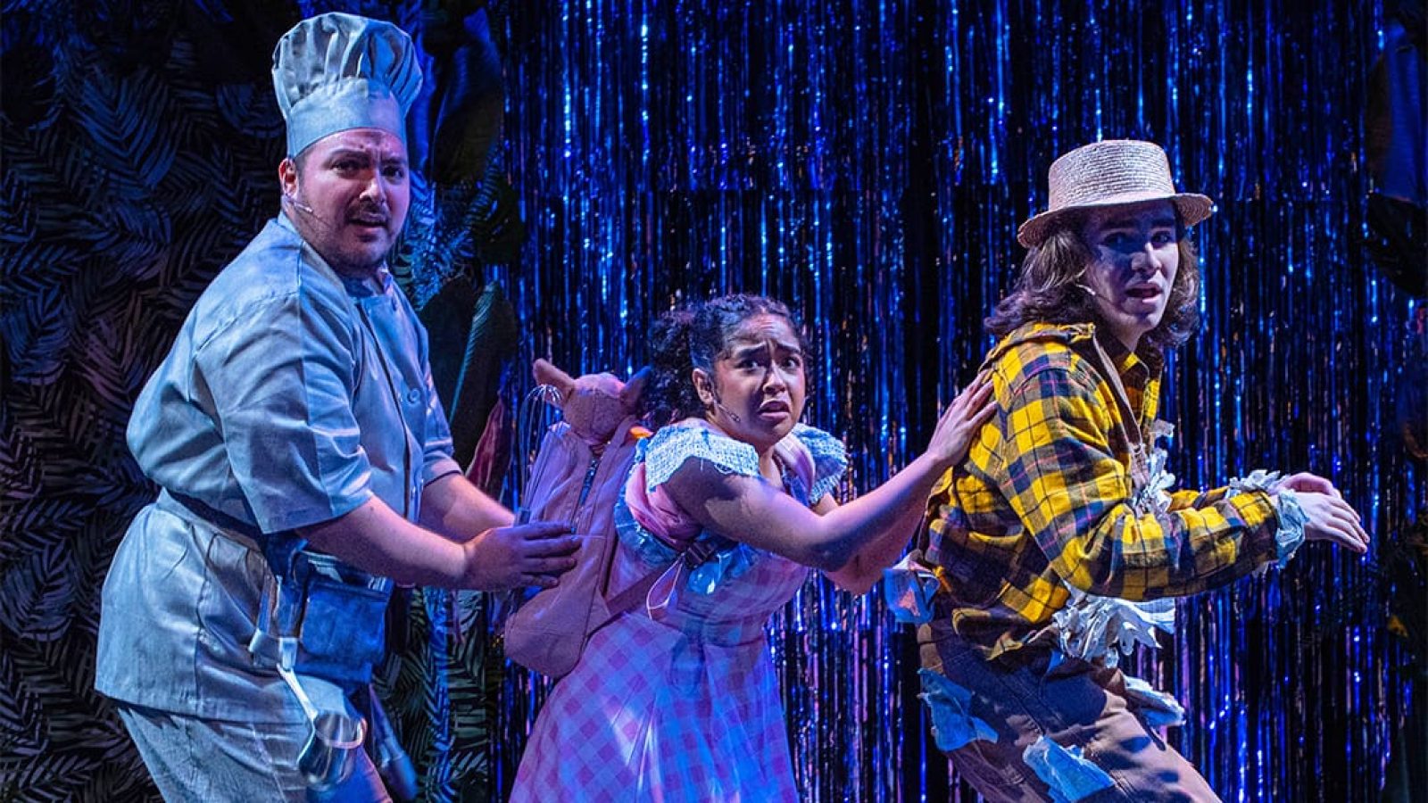 Actors in costumes from El Otro Oz musical production on stage