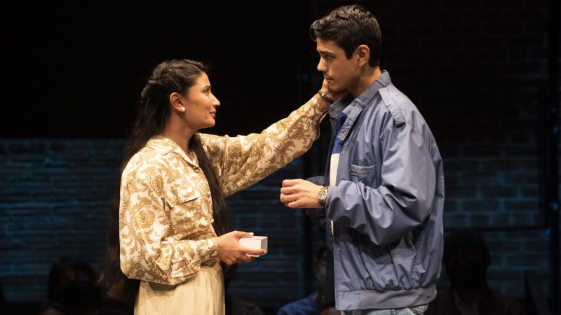 Actors on stage in a play, a woman touching a man's face. Edgerton Awards.