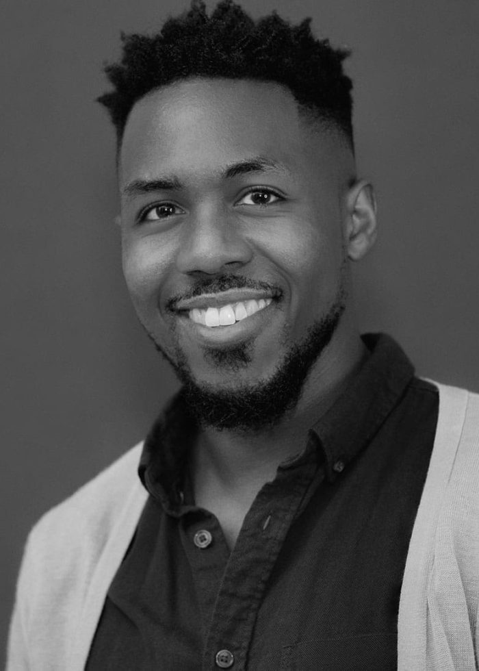 Eric Lockley smiles in a headshot, wearing a dark shirt and cardigan.