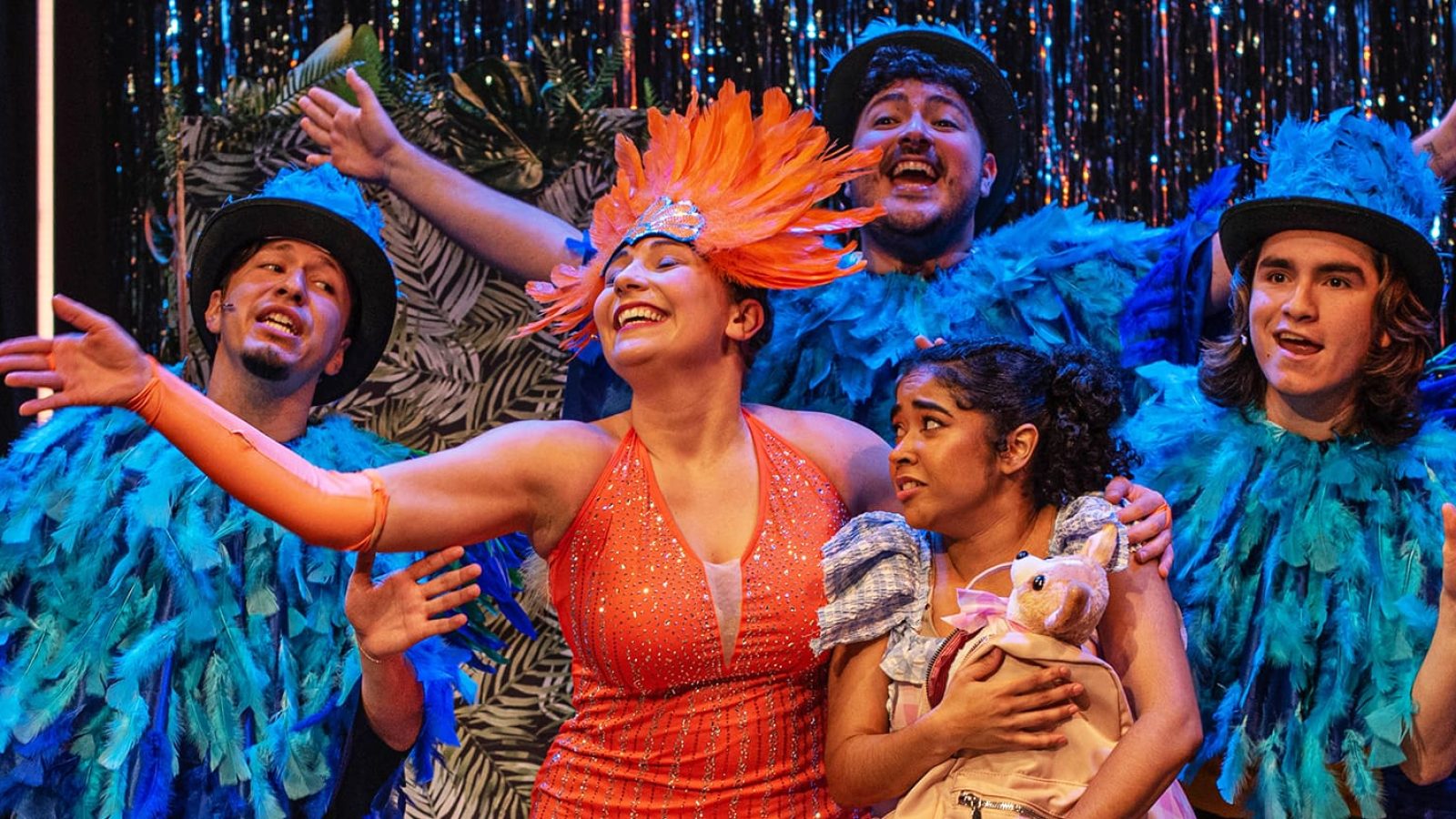 Cast of El Otro Oz in colorful costumes on stage at the Atlantic Theater Company.