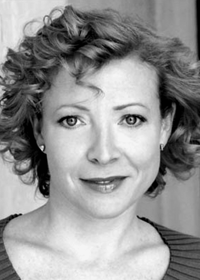 Elizabeth Canavan, actress, smiling in a headshot with curly hair.