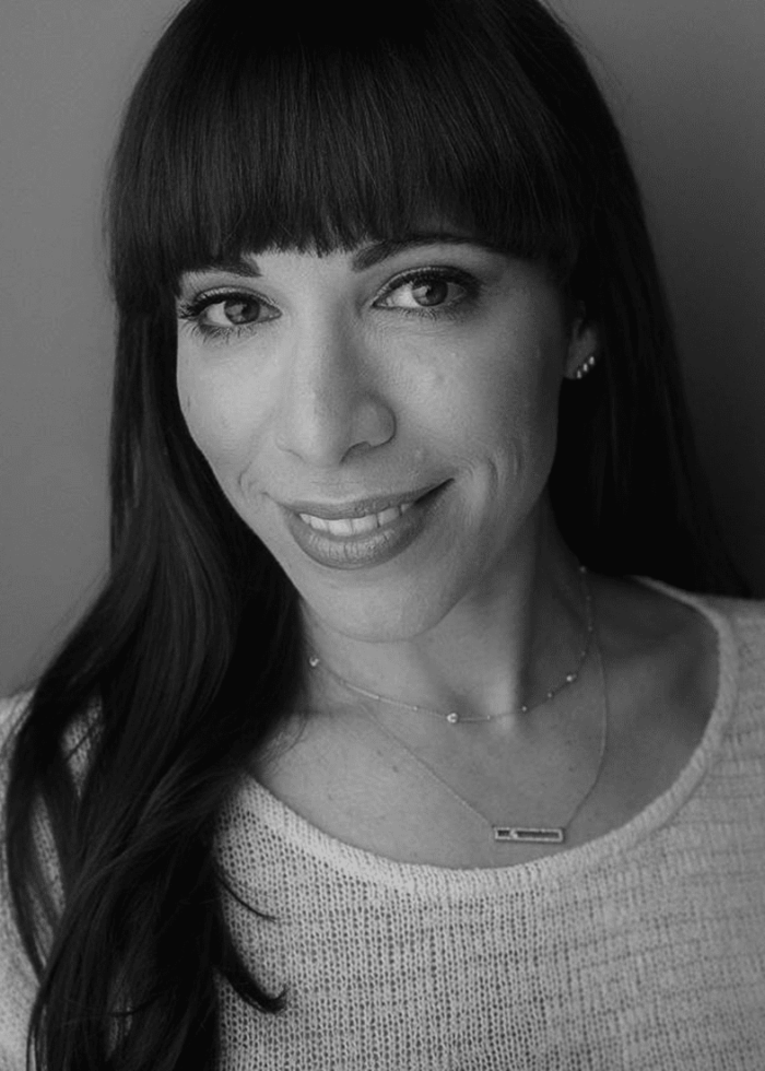 Ellyn Marie Marsh smiling, with dark hair and bangs, wearing a necklace
