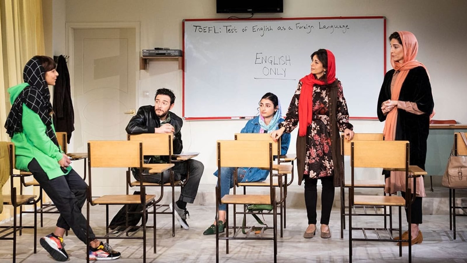 Students in an English class, focusing on TOEFL exam prep. "English Only" whiteboard visible.