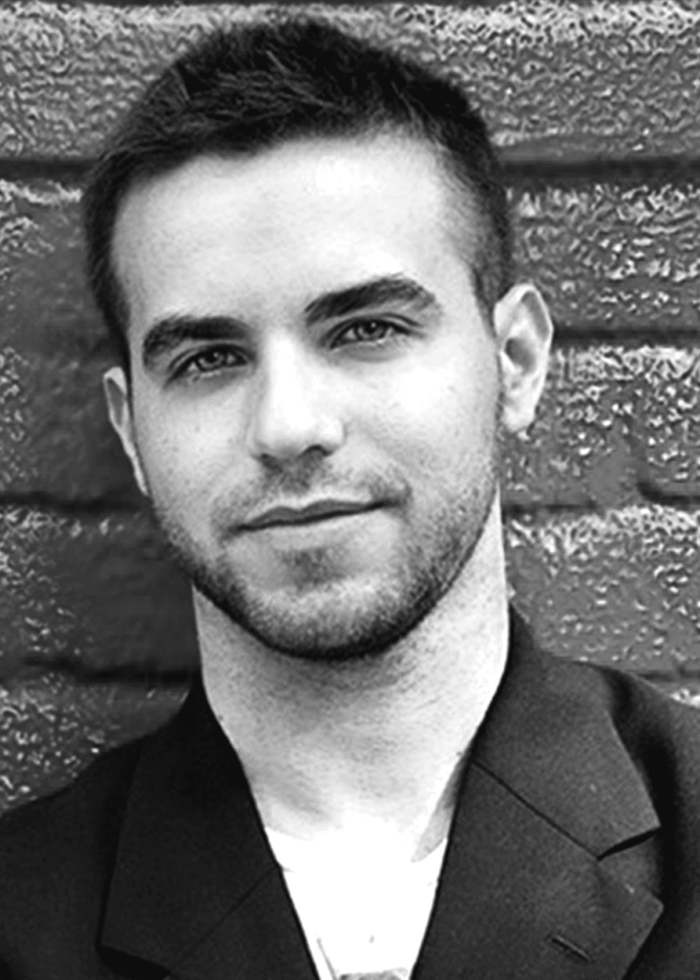 Ethan Pakchar, young man with dark hair and beard, wearing a blazer.