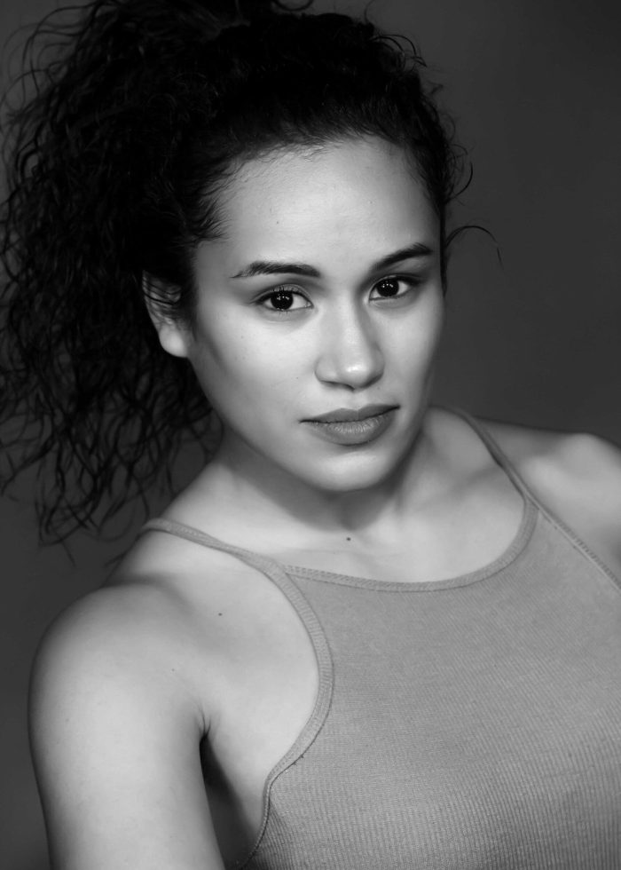 Felicia Santiago portrait, looking directly at the camera with a serious expression.