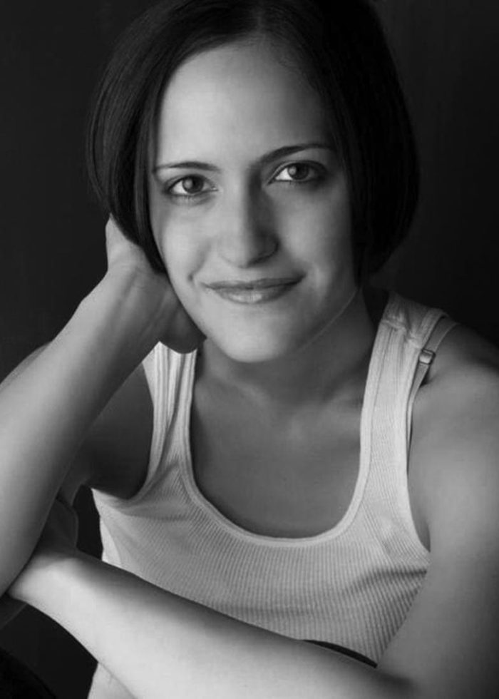 Fernanda Coppel portrait in a black and white studio photo, smiling slightly