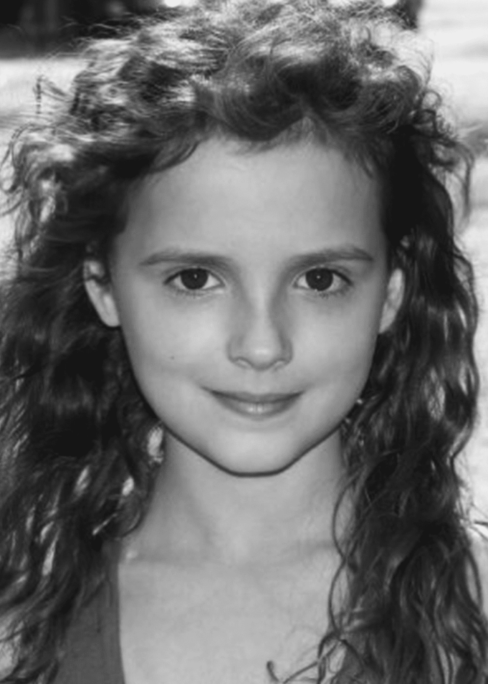 Fina Strazza with long curly hair, smiling at the camera
