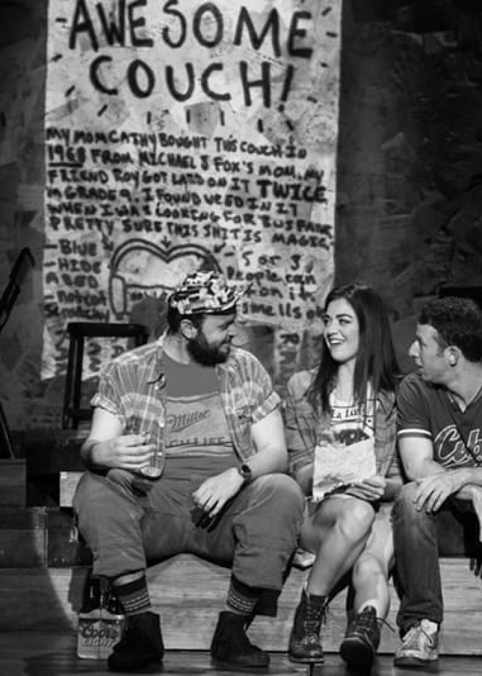 Cast of "Found" musical sitting on a bench with the "Awesome Couch!" sign in the background.