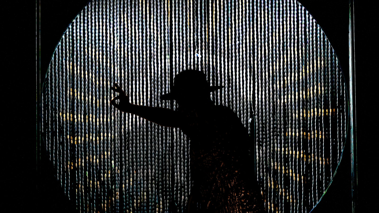 Silhouette of a person reaching towards a textured, circular backdrop. A Freeky Introduction.