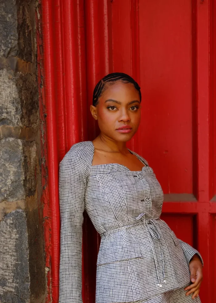 Gabby Beans leans against a red door in a houndstooth blazer, from the blog "Bold Enough to Go Full-Tilt