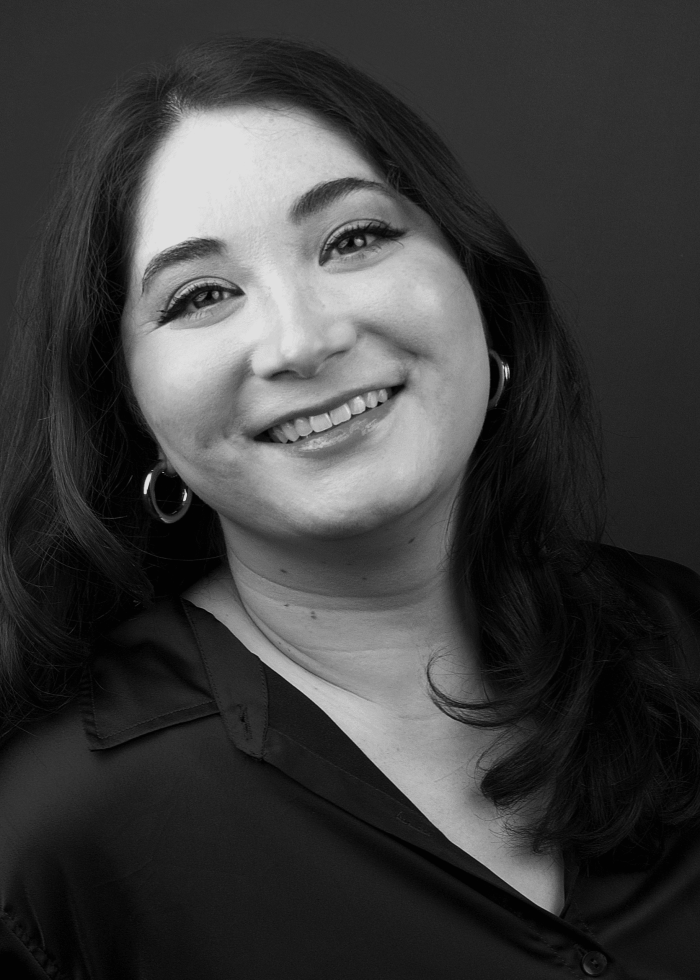 Smiling woman with dark hair and hoop earrings in black and white portrait