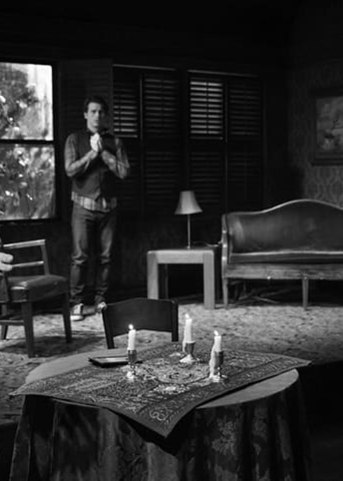 Scene from David Mamet's 'Ghost Stories' play: actors on stage with a table set for a seance.