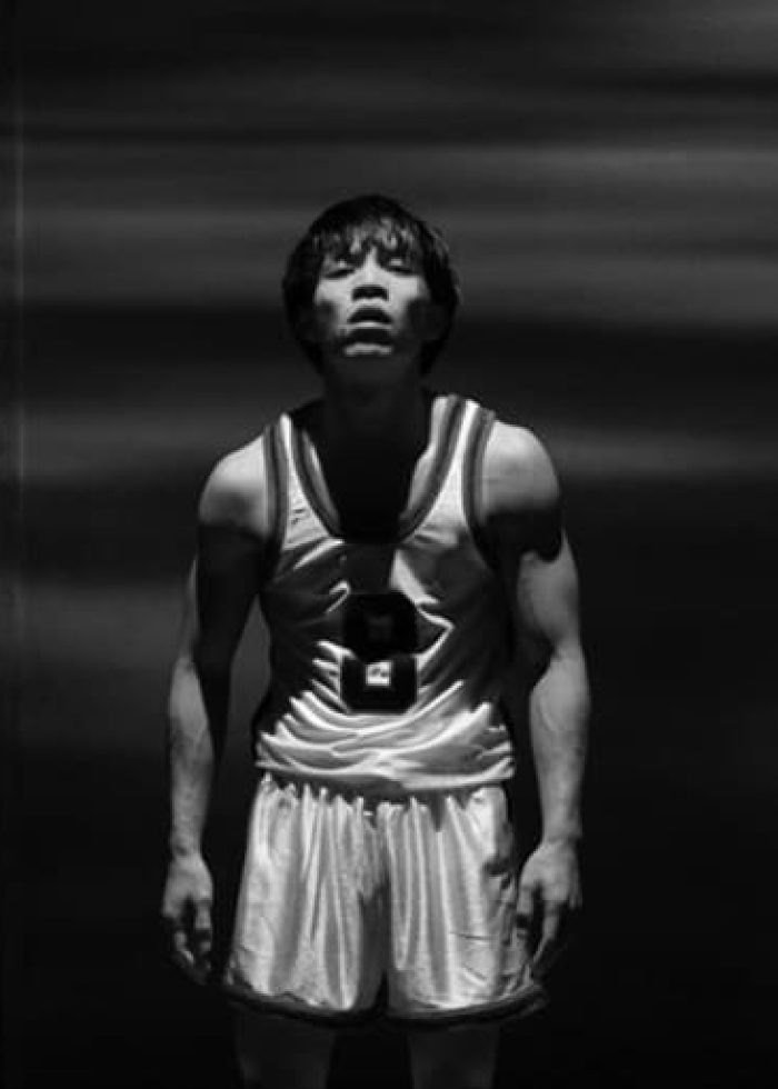 Basketball player in jersey number 8 looks up, dramatic lighting