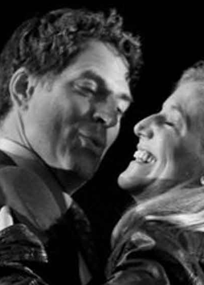 Actors in a scene from "Harper Regan" sharing a moment, smiling