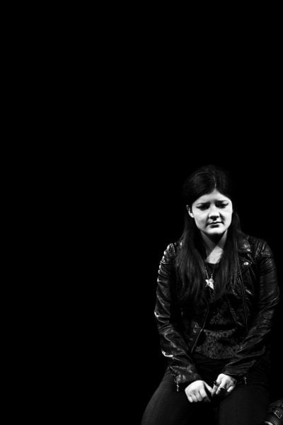 Two women in leather jackets, one looking down, the other looking up. Harper Regan.