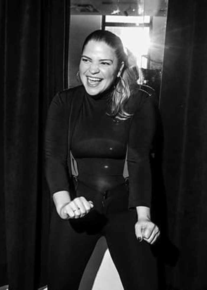 Playwright smiling and laughing backstage in black outfit