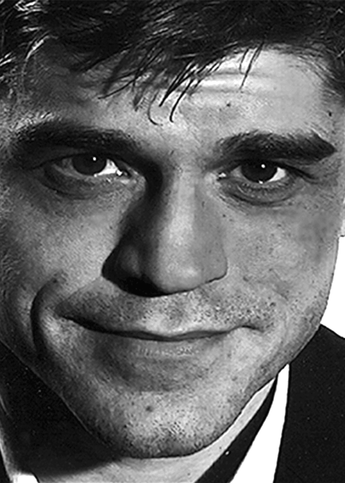 Close-up portrait of Juan Carlos Hernández, smiling slightly in black and white.