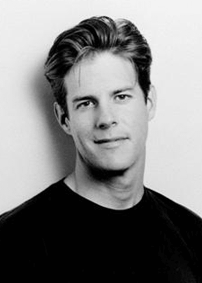 Rick Holmes headshot in black and white, wearing a black t-shirt.