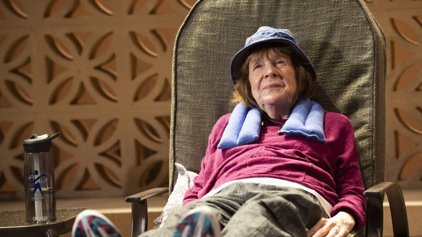 Senior woman relaxing in chair after Infinite Life health class.