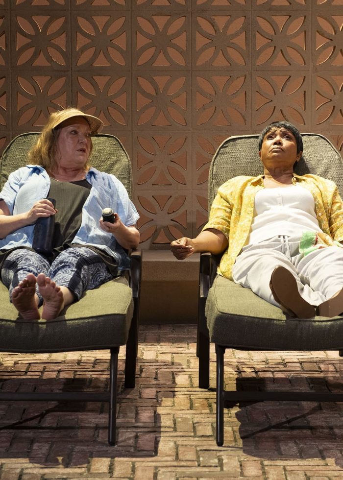 Two women relax in lounge chairs, holding hands. Enjoying infinite life's simple pleasures.