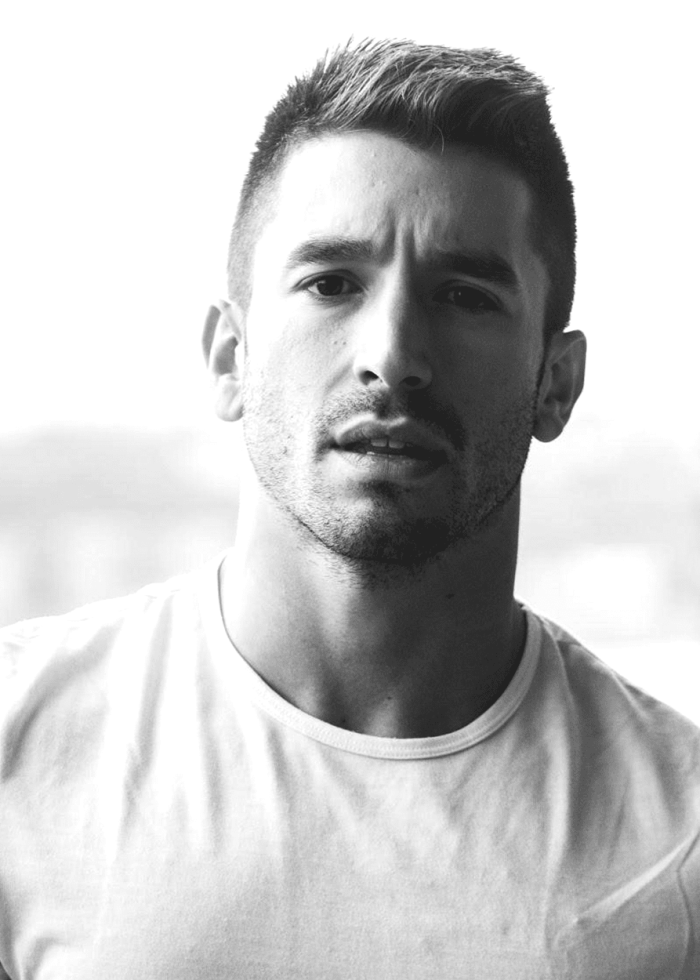 Man with short hair and beard in a black and white portrait.