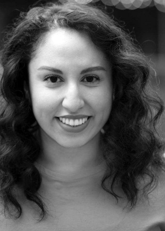 Smiling woman with curly hair, looking at the camera