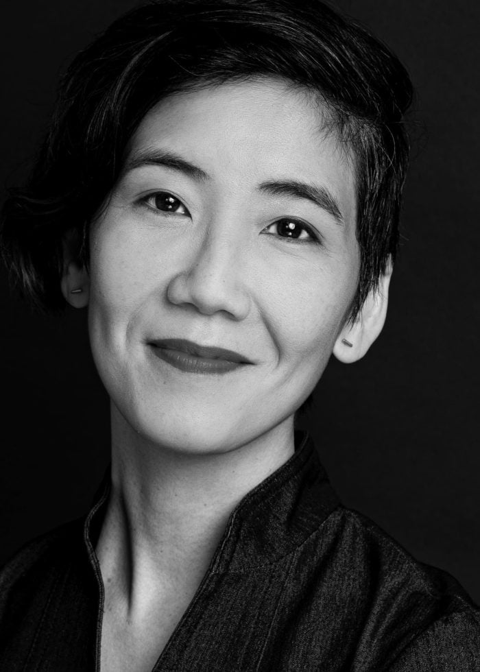 Jennifer Chang smiling, wearing a dark jacket, looking at the camera.