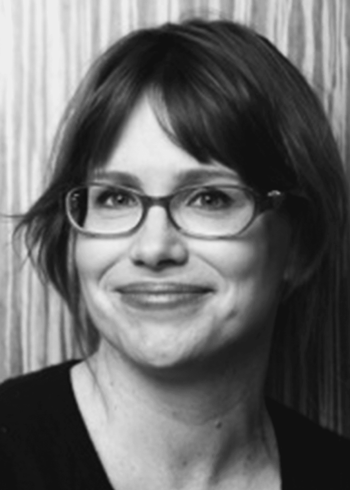 Jennifer Crittenden wearing glasses, smiling for a portrait.
