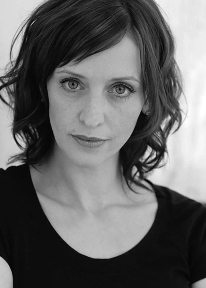 Actress Jessica Stone looking directly at the camera with short, wavy hair.