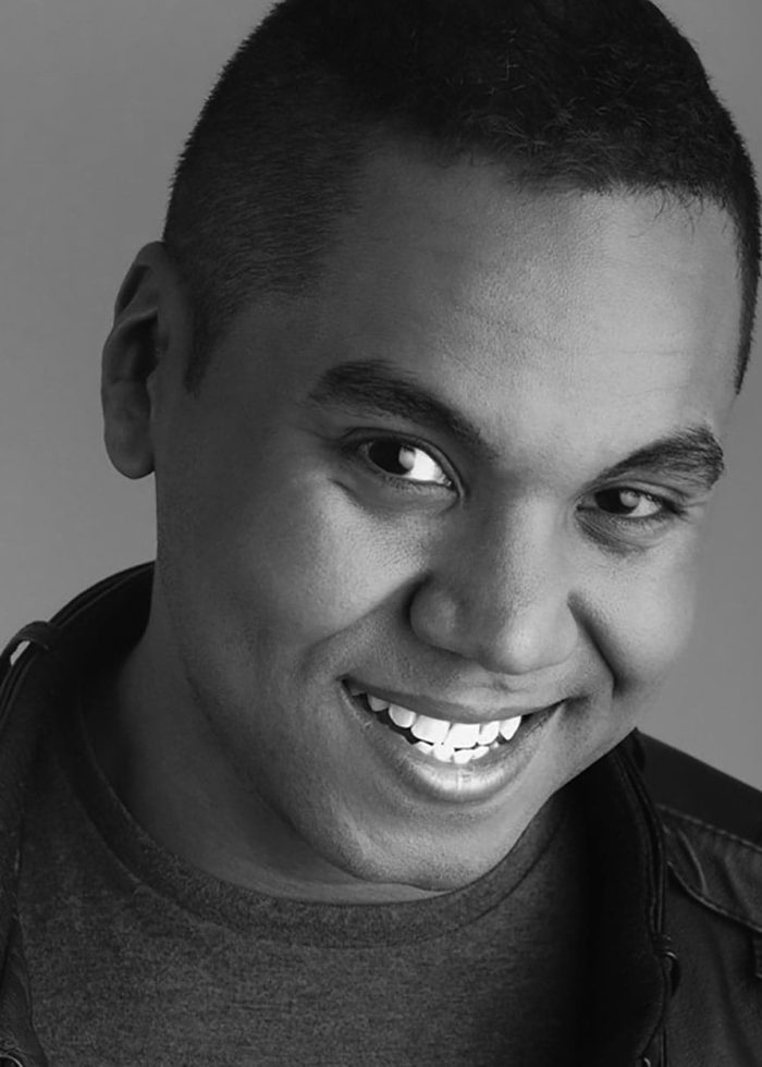 Jesus E. Martinez smiling in a black and white headshot, wearing a leather jacket.
