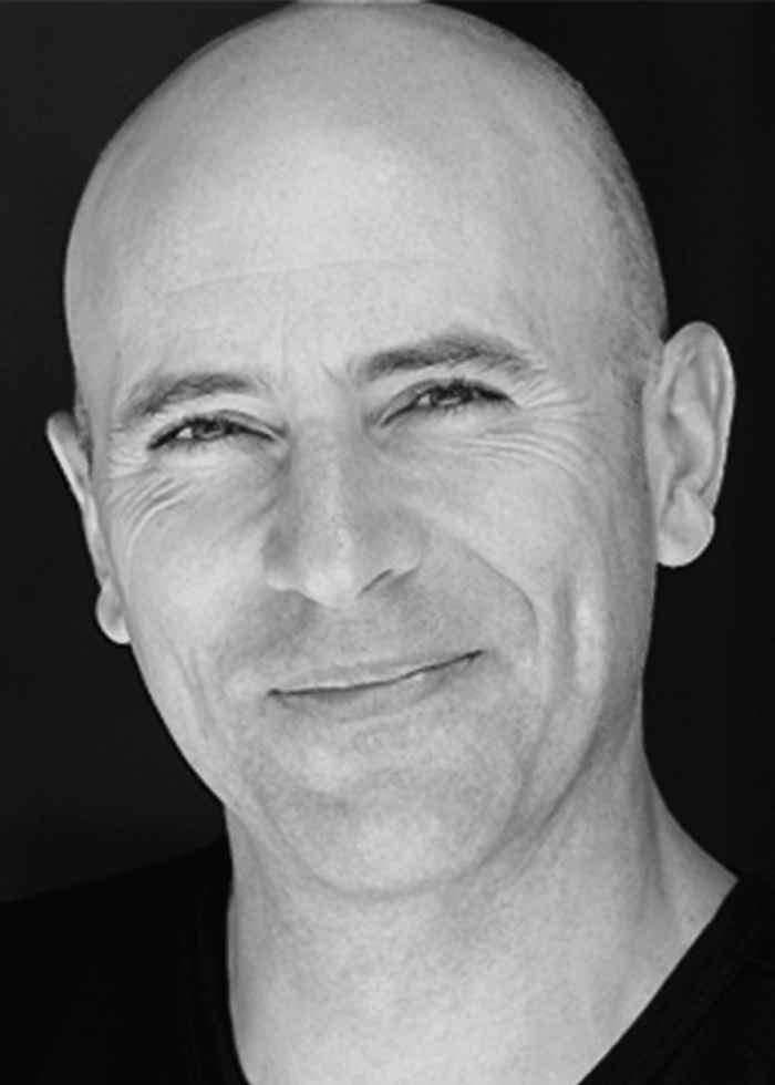 Jordan Lage, bald man smiling, headshot