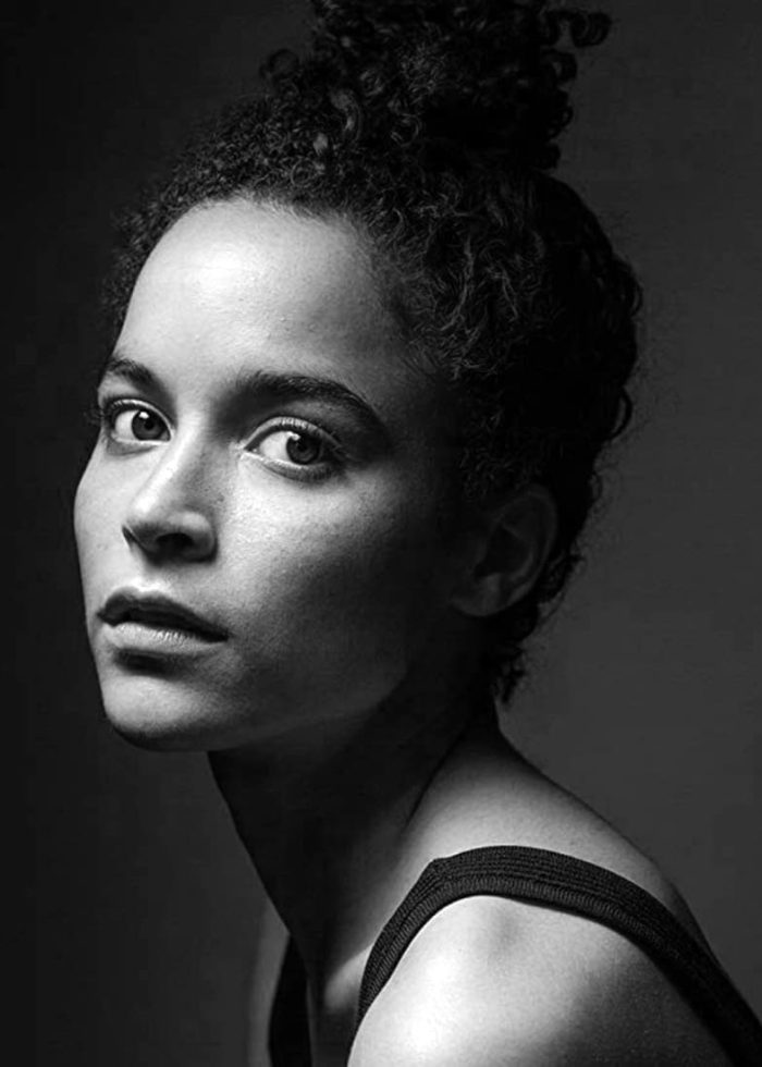Juliana Canfield in a dramatic black and white portrait, looking intensely at the camera.